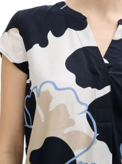 Blouse bleue avec des motifs fleuris une coupe droite et un col v