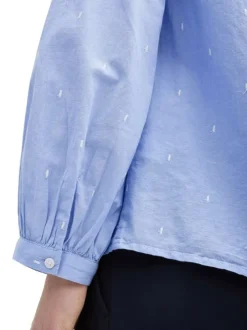 Blouse en coton bleue à pois avec une coupe ample et un col v