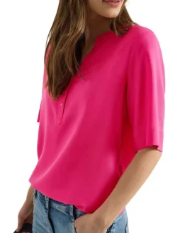 Blouse fuchsia unie pourvue de manches courtes et d'un col tunisien