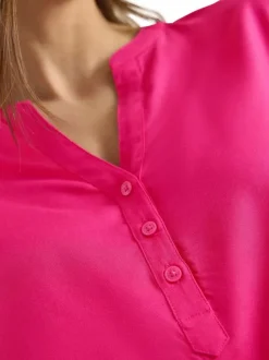 Blouse fuchsia unie pourvue de manches courtes et d'un col tunisien