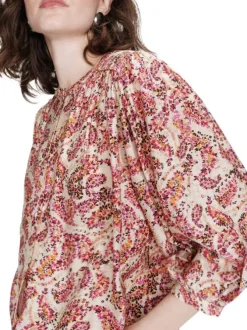 Blouse rose à motifs pourvue d'un col rond et de manches longues