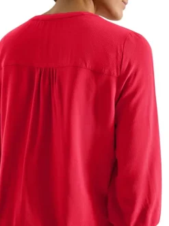 Blouse rouge unie pourvue d'une coupe large et d'un col tunisien