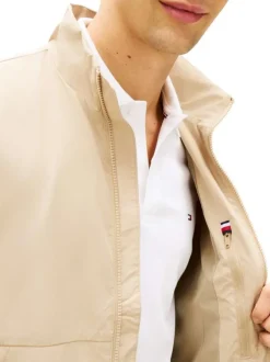 Blouson beige pourvu d'une fermeture zippée ton sur ton et du patch de la marque