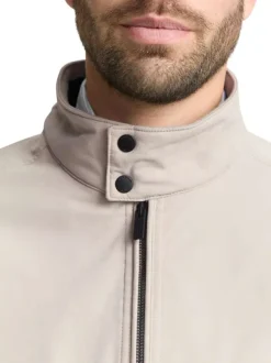 Blouson beige uni avec une coupe droite et deux poches raglan à l’avant