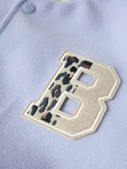 Bomber lilas pourvu d'une fermeture boutonnée et de poches plaquées