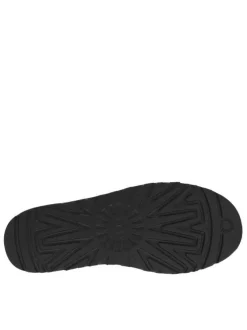 Boots en cuir noires à talon plat avec des surpiqûres noires et blanches