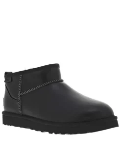 Boots en cuir noires à talon plat avec des surpiqûres noires et blanches