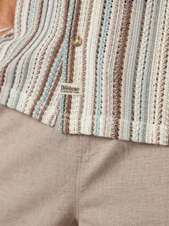 Chemise beige à rayures pourvue d'une coupe droite et d'un col boutonné