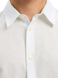 Chemise en lin et coton blanche uni avec une coupe ajustée et un col boutonné