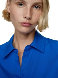 Chemisier bleu uni avec une coupe large un col français et à manches longues