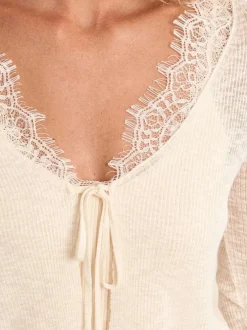 Gilet blanc uni pourvu d'une coupe droite et de détails en dentelle