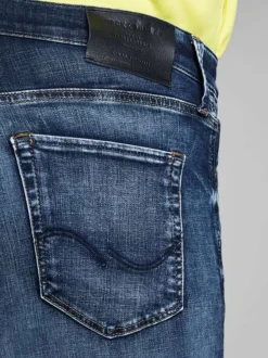 Jean bleu délavé avec une coupe ajustée et une fermeture zippée boutonnée