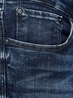 Jean bleu délavé avec une coupe ajustée et une fermeture zippée boutonnée