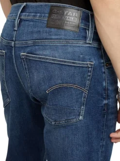 Jean en coton bleu avec des passants pour ceinture et une coupe slim
