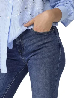 Jean en coton bleu légèrement délavé avec une coupe slim et une taille-haute