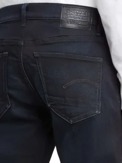 Jean noir avec une coupe slim à poches et des passants pour ceinture
