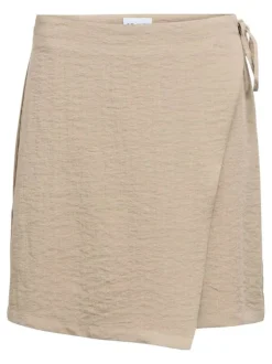 Jupe courte beige unie ajustable pourvue d'une coupe asymétrique
