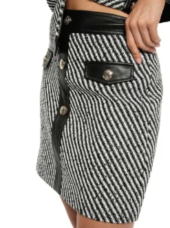 Jupe courte noire et blanche rayée en tissu tweed ornée de boutons
