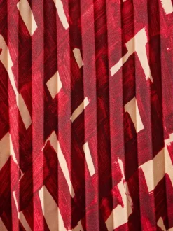 Jupe longue plissée à motif rouge imprimé avec une coupe droite