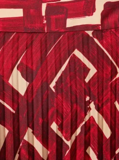 Jupe longue plissée à motif rouge imprimé avec une coupe droite
