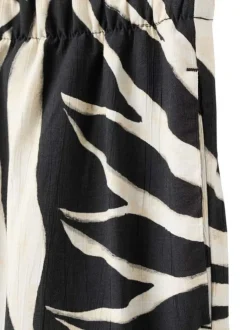 Pantalon beige à motifs pourvu d'une taille élastiquée et d'une coupe large