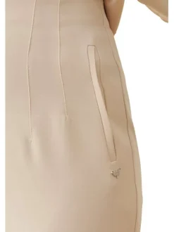 Pantalon beige uni avec une coupe slim et logo de la marque en bijou argenté