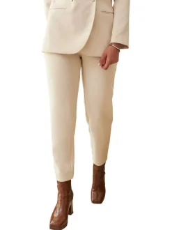 Pantalon beige uni avec une coupe slim et logo de la marque en bijou argenté