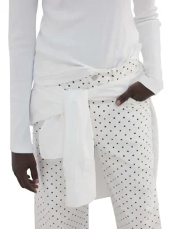 Pantalon en coton blanc à pois pourvu de passants pour la ceinture