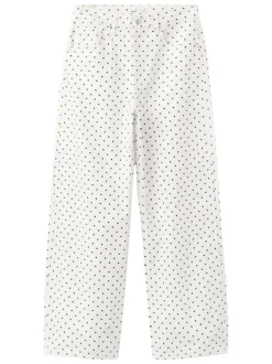 Pantalon en coton blanc à pois pourvu de passants pour la ceinture