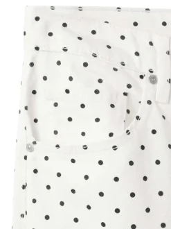 Pantalon en coton blanc à pois pourvu de passants pour la ceinture