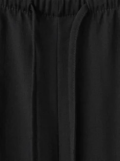 Pantalon noir uni pourvu d'une coupe droite et d'une taille élastiquée