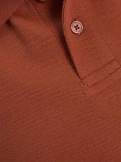 Polo en coton brique uni avec une coupe droite et un col boutonné
