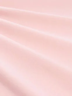 Polo rose uni pourvu de manches courtes et d'un col boutonné