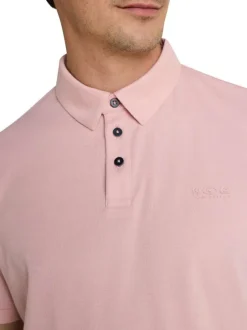 Polo rose uni pourvu de manches courtes et d'un col boutonné
