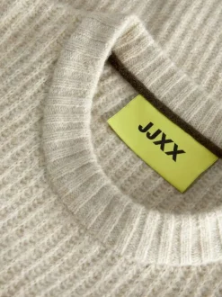 Pull beige uni en maille avec une coupe oversize et un col rond