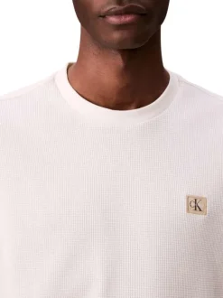 Pull blanc uni texturé avec un petit patch brodé et à col rond