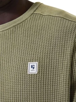 Pull en coton kaki uni en maille tricotée avec patch de la marque