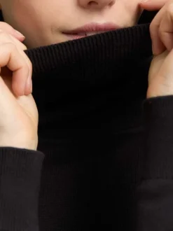 Pull en coton noir uni avec un col roulé et des manches longues
