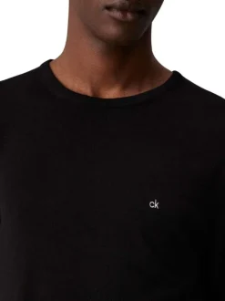 Pull en coton noir uni avec une coupe droite un col rond et le logo en petit