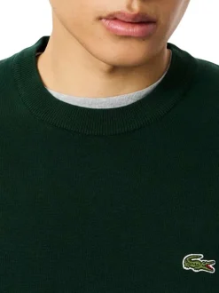 Pull en coton vert foncé avec un col rond et des manches longues