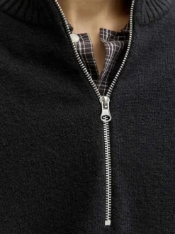 Pull noir uni en maille fine avec un col camionneur et des manches longues