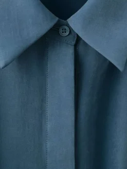 Robe longue bleue unie pourvue d'une coupe cintrée et d'un col chemise