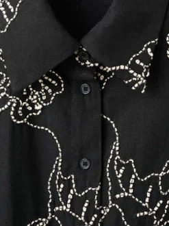 Robe longue noire unie pourvue de broderies florales contrastées