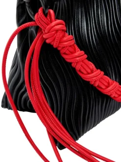 Sac bandoulière noir uni avec une anse rouge et une bandoulière réglable