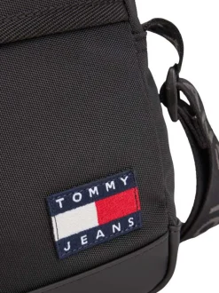 Sacoche noire unie une poche zippée à l'avant et logo iconique