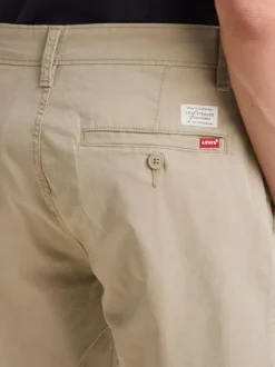 Short en coton beige uni avec une forme chino et une coupe longue