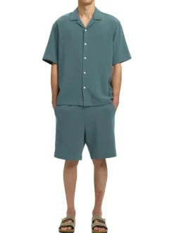 Short en coton vert uni pourvu d'une taille élastiquée et d'une coupe droite