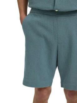 Short en coton vert uni pourvu d'une taille élastiquée et d'une coupe droite