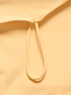 Top pêche uni crop top avec une coupe ajustée, un col rond et des bretelles