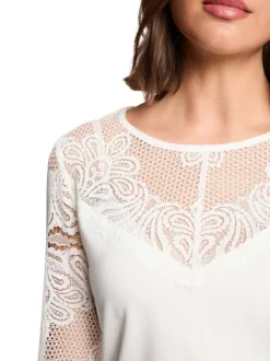Top blanc floral avec une coupe droite et des manches longues